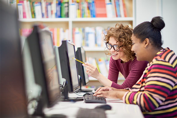 Personne expliquant à une autre via un ordinateur - Accompagner un collaborateur par le tutorat